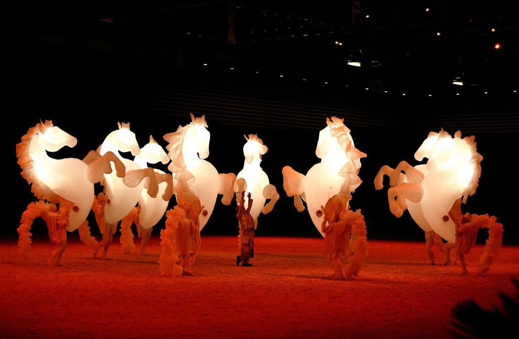 室內舞台紅光下白馬群表演